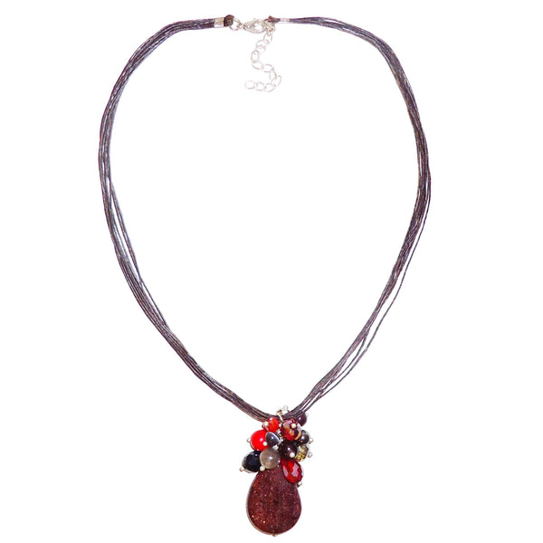 Mahogany red stone with crystal cluster pendant on multiple wax linen cording, available at Cerulean Arts.  