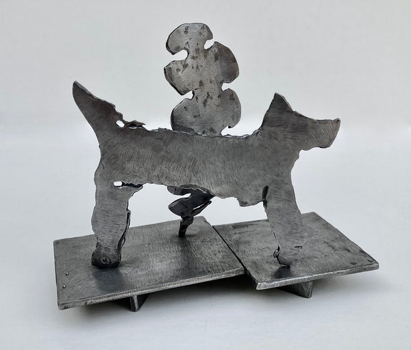Abstract steel sculpture depicting a dog and a tree shape.