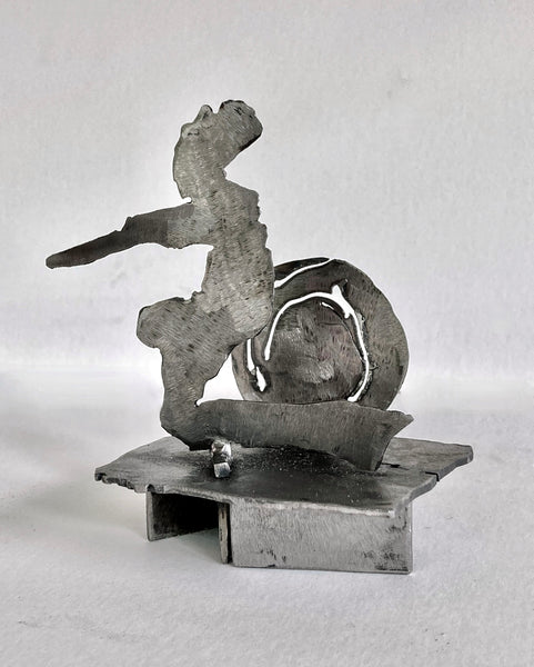 Abstract steel sculpture depicting a human figure and circular shape.