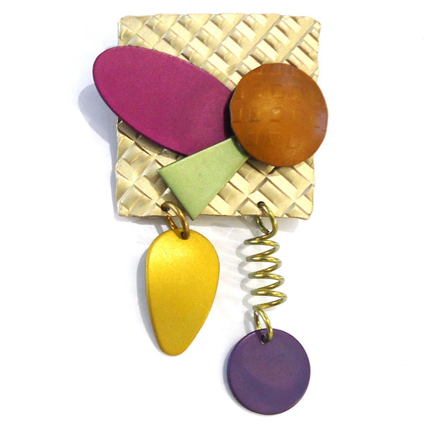 Square handmade aluminum brooch with layered geometric shapes in bright pink, yellow and purple