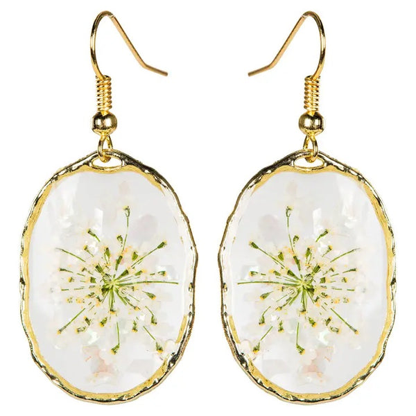 Oval earrings with real dried flowers encased in resin with gold colored edging, available at Cerulean Arts.