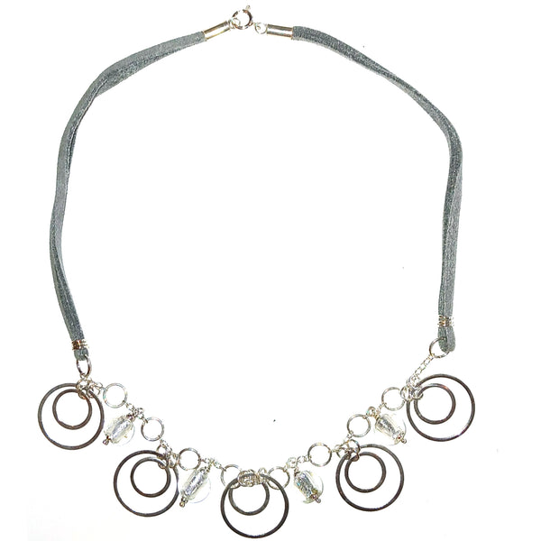 Necklace with sterling silver circular charms and Murano glass beads on a gray suede cord.