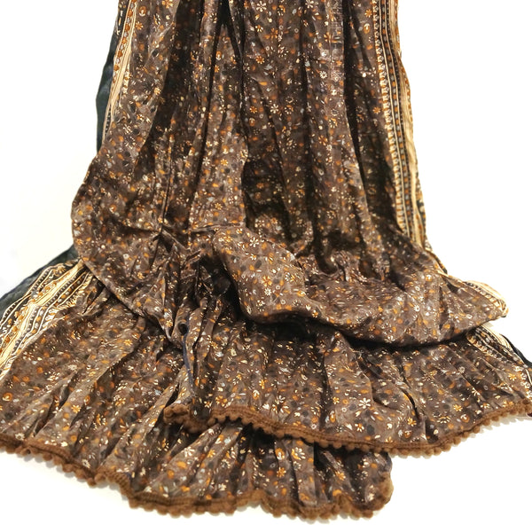 A close-up of a dark brown silk scarf with an allover small floral print and gold-toned border details.