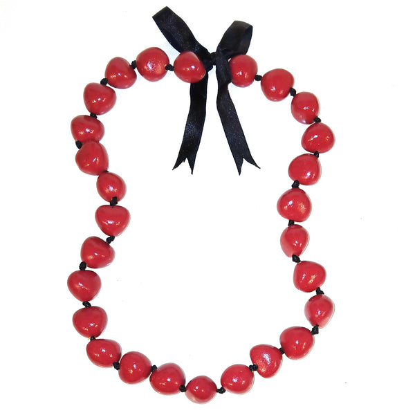 A red beaded necklace made of glossy round beads strung on a black cord, tied with a black ribbon bow at the top.