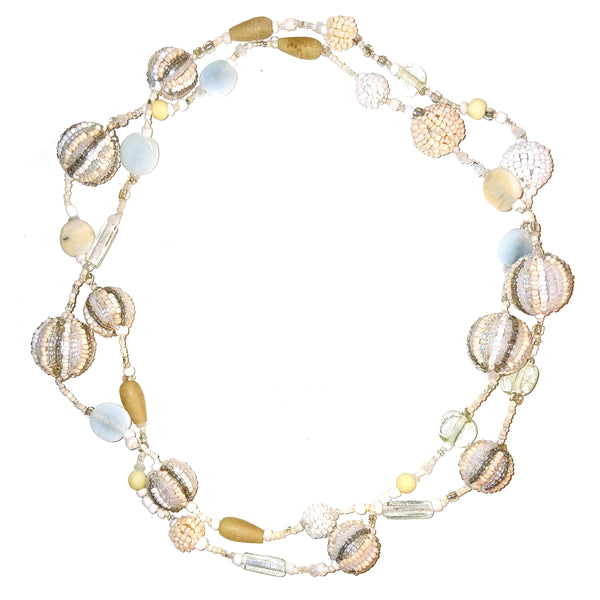 A beaded strand necklace featuring textured glass beads in metallic gold, silver, and cream, with translucent pale yellow beads.