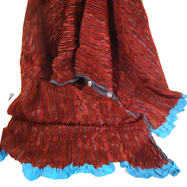 Burgundy textured scarf with a blue edge.