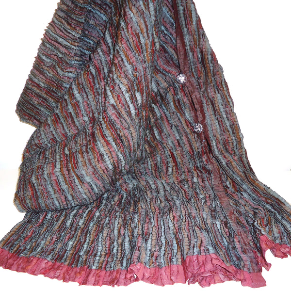 Multicolored textured scarf with a pink edge.