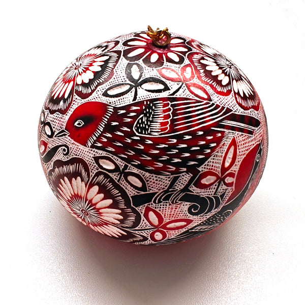Decorative gourd ornament with intricate black, red, and white patterns of birds