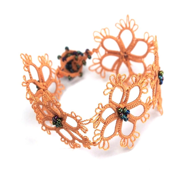 Silk crocheted gerbera bracelet in apricot with gray seed beads available at Cerulean Arts. 