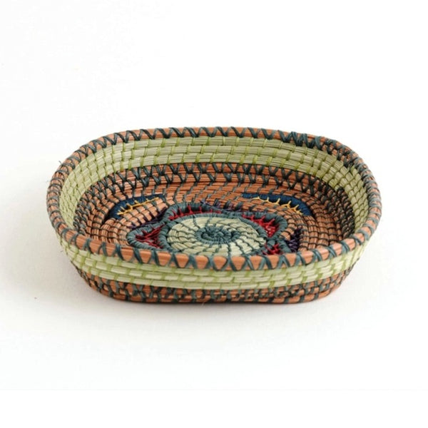 Square basket with elaborate open weave work made from pine needles, native grasses and colored raffia accents, available at Cerulean Arts