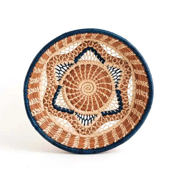 Woven basket with star shape pattern made from pine needles, native grasses and colored raffia accents, available at Cerulean Arts. 