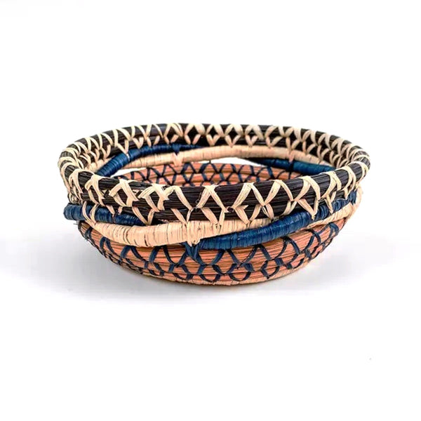 Woven basket featuring intricate pattern made from pine needles, native grasses and colored raffia accents, available at Cerulean Arts. 