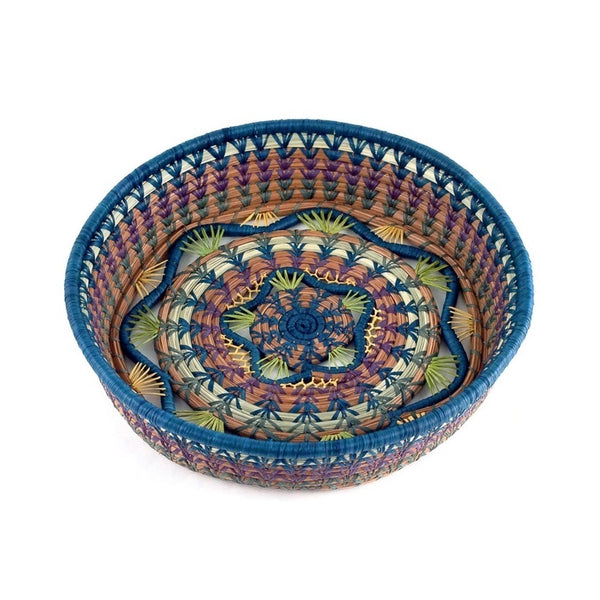 Woven basket with intricate star shape pattern made from pine needles, native grasses and colored raffia accents, available at Cerulean Arts. 