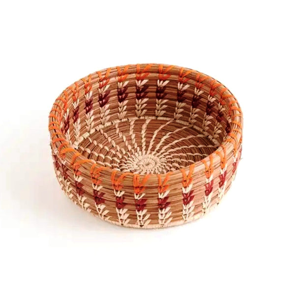 Woven basket with deep sides made from pine needles and colored raffia accents, available at Cerulean Arts. 