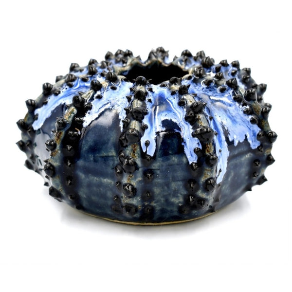 Sea urchin-shaped porcelain bud vase with variegated deep blue glaze available at Cerulean Arts. 