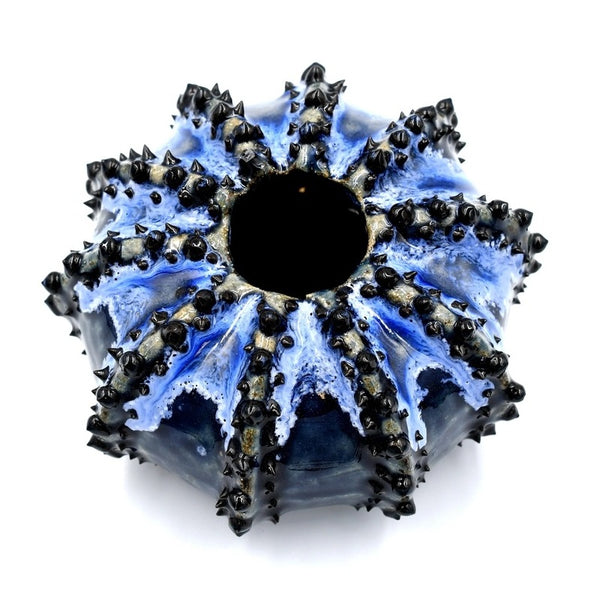 Sea urchin-shaped porcelain bud vase with variegated deep blue glaze available at Cerulean Arts. 