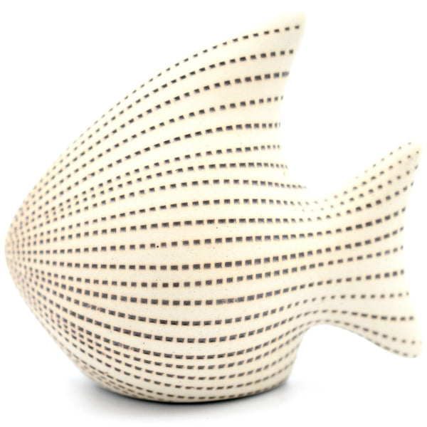 A fish-shaped decorative object with a cream-colored surface covered in horizontal rows of small dark dotted lines.