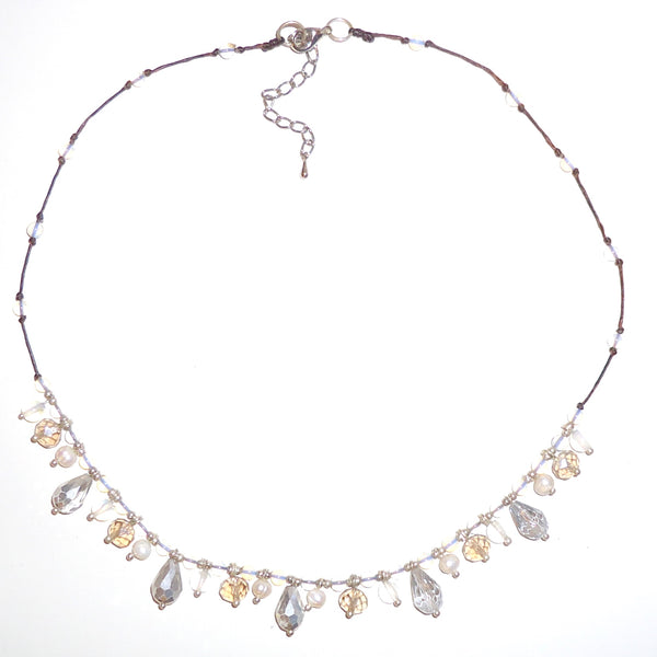 Faceted drop bead necklace in shades of white on wax linen cording available at Cerulean Arts. 