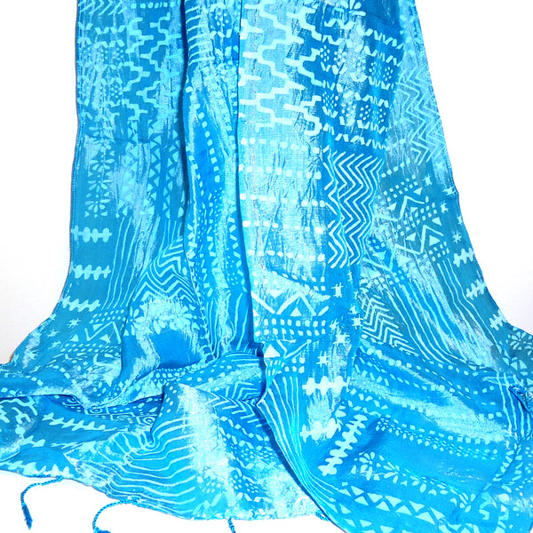 Silk scarf in iridescent teal printed with a lighter geometric motif, available at Cerulean Arts. 