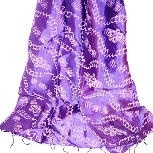 Silk scarf in iridescent purple printed with a pink floral motif, available at Cerulean Arts.