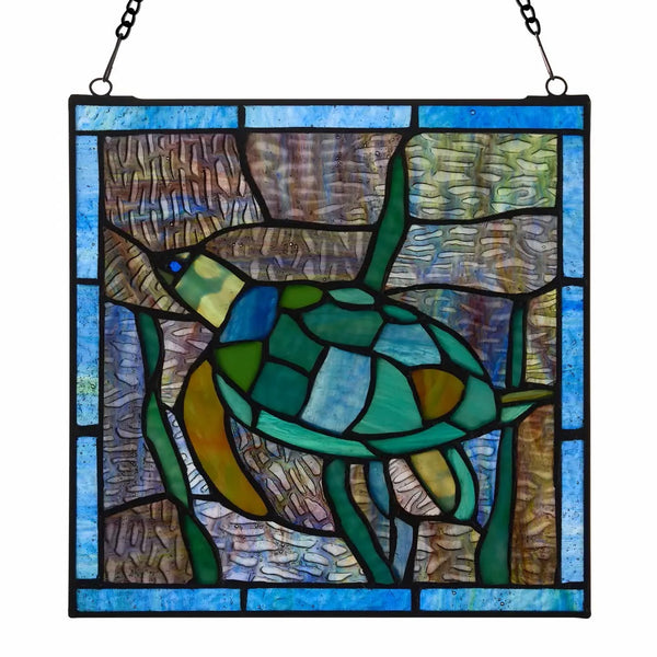 A stained glass hanging panel featuring a sea turtle swimming underwater, surrounded by blue border tiles and textured background pieces in shades of green, blue, brown, and yellow. The panel is suspended by a black chain.