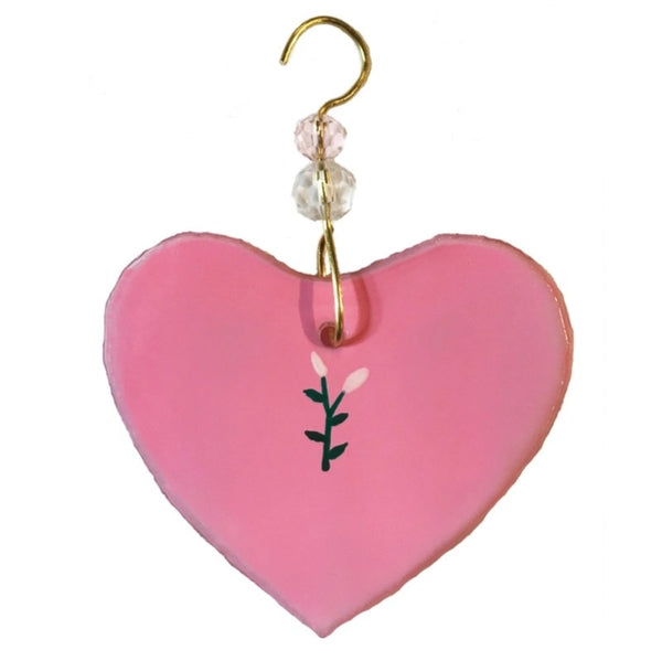 Fused glass suncatcher of a pink heart with flower accent made from recycled wine bottles, available at Cerulean Arts.