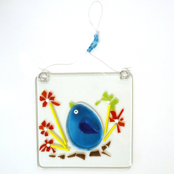 Fused glass suncatcher featuring a bluebird sitting on a flowering branch, available at Cerulean Arts.