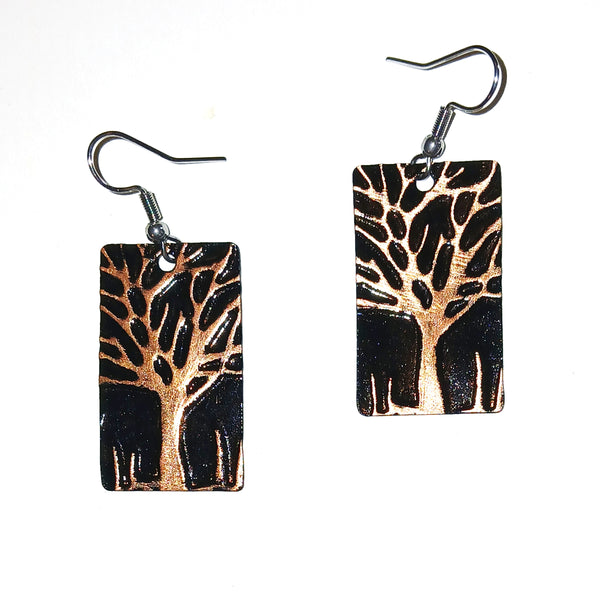 Pair of earrings with tree design on a black background