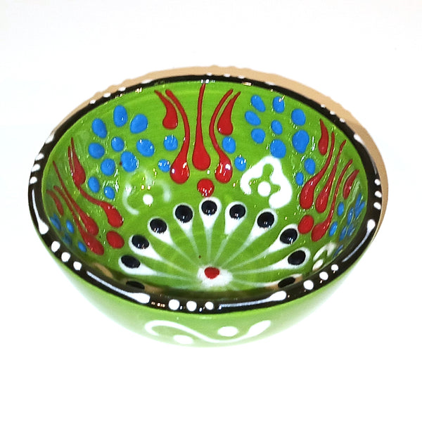 Decorative ceramic bowl with colorful patterns on a green background