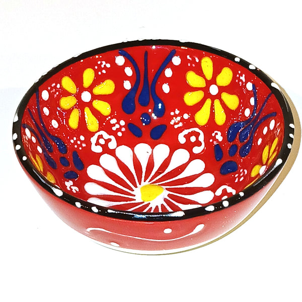 Decorative bowl with colorful floral patterns on a red background
