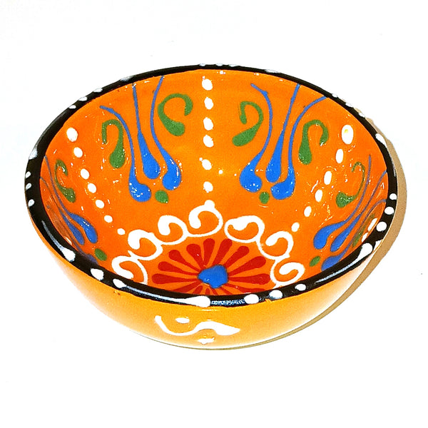 Decorative ceramic bowl with colorful patterns on an orange background