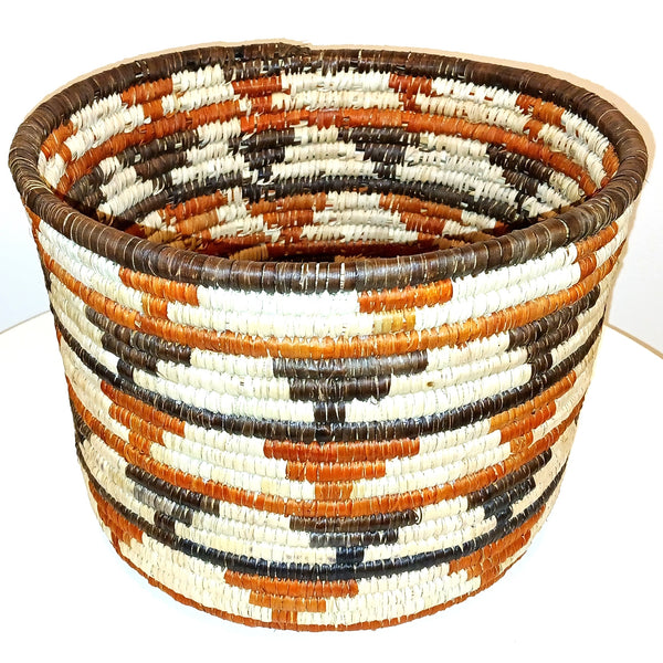 Woven basket with a pattern of brown, orange, and beige colors 