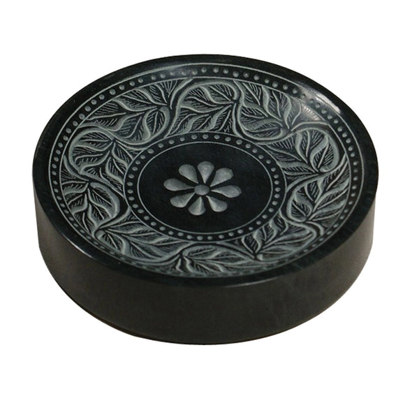 A round black stone soap dish with a carved floral and leaf pattern, shown on a plain white background.