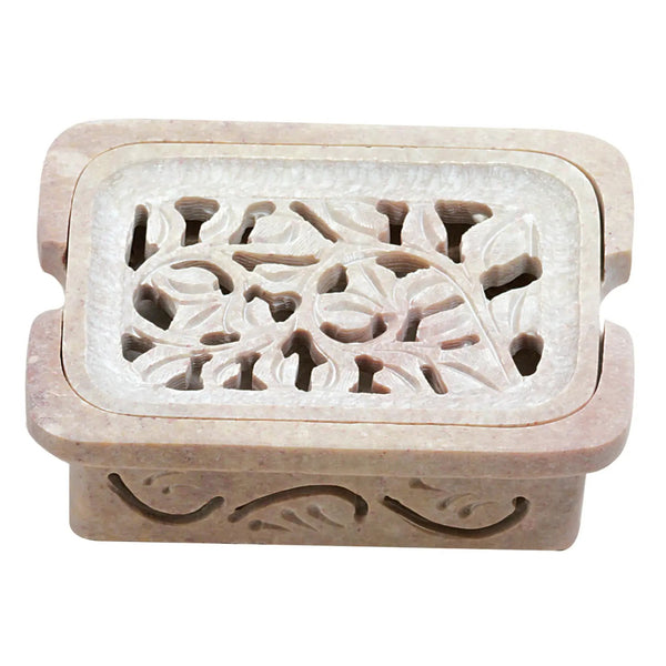 Carved soapstone soap dish with floral pattern on a white background .