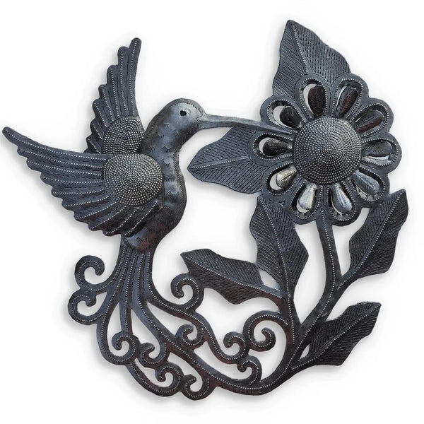 Metal wall sculpture of a hummingbird next to a blooming flower