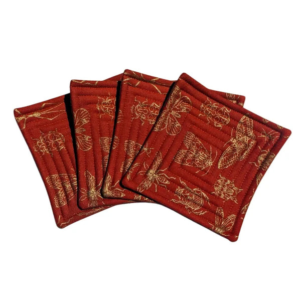 Quilted fabric coaster set with orange background and gold insect pattern.