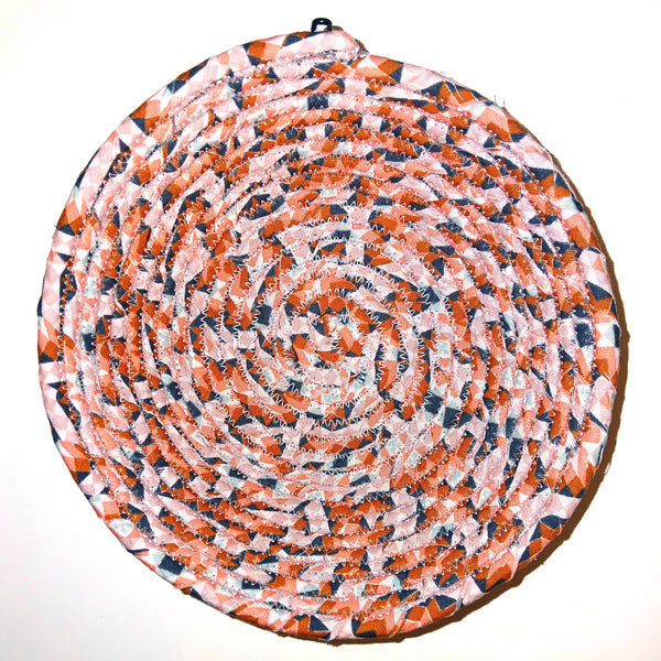 Fabric bowl with mixed prints in salmon pink colors.