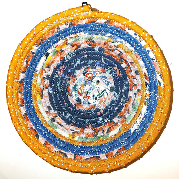 Fabric bowl with mixed prints in blue and orange colors.