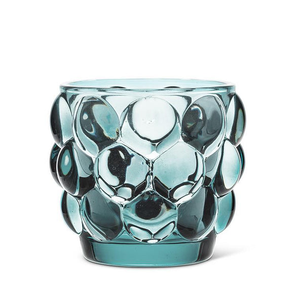 Blue glass votive holder with bubble pattern.