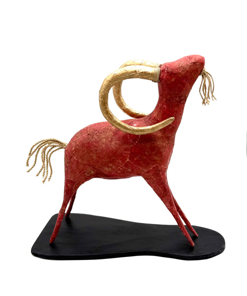 Red and gold ram sculpture on a black base
