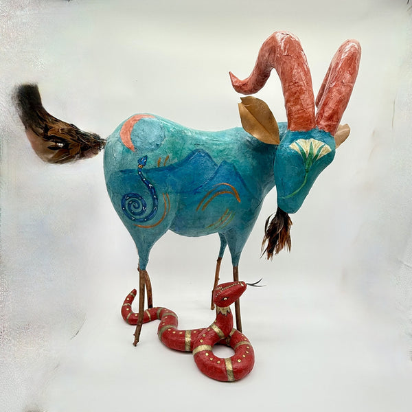 Colorful sculpture of a goat with a snake 