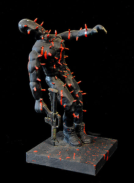 Statue of a muscular figure with red accents holding a machine gun on a black background