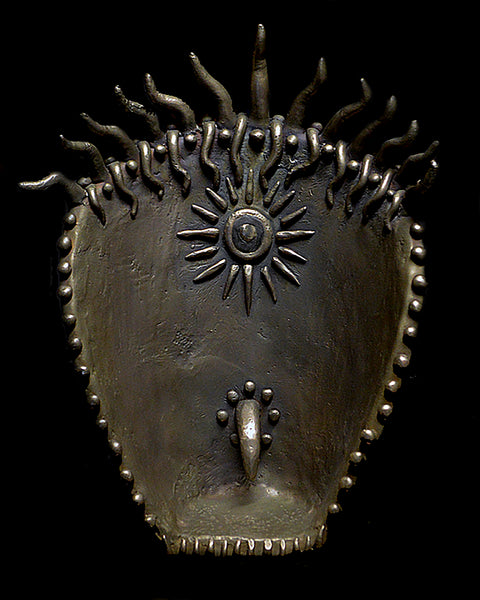 Bronze sculpture with sun design on a black background