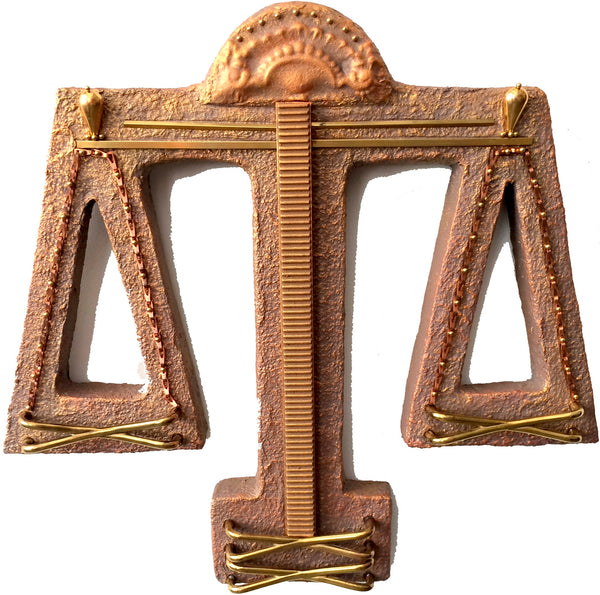 Bronze and gold decorative item resembling a balance scale on a white background