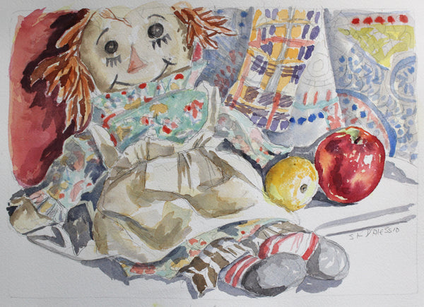 Watercolor painting of a rag doll with apples and a plaid cloth on a textured surface.