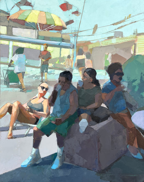 People sitting on a bench under a colorful umbrella in a lively outdoor setting.