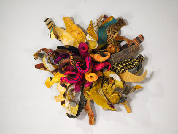 Sculpture made of assorted colorful fabric scraps on a white background