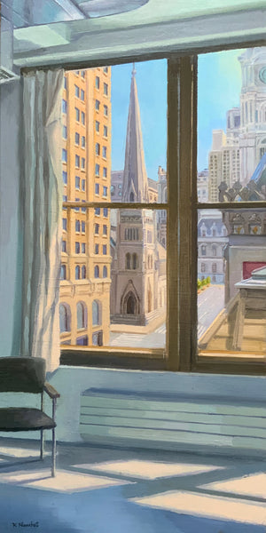 Cityscape view from a window with a chair and radiator in the foreground