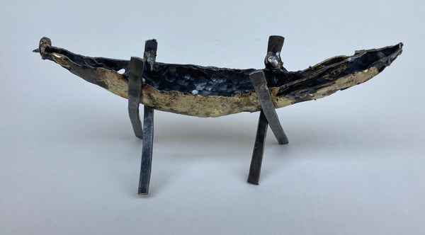 Abstract metal sculpture depicting a boat on two x-stands.