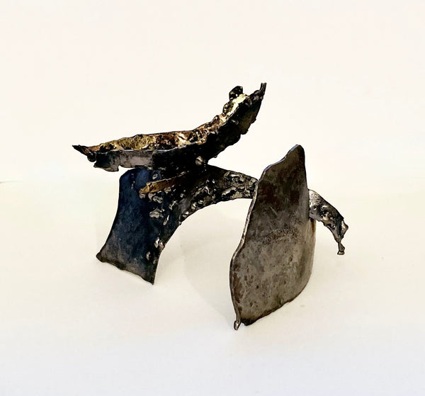 Abstract metallic sculpture with curved forms balanced on each other